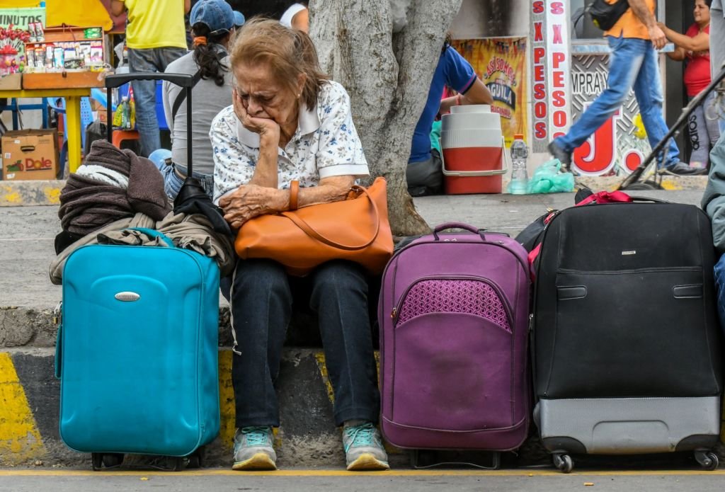 Una mujer sentada junto a varias maletas