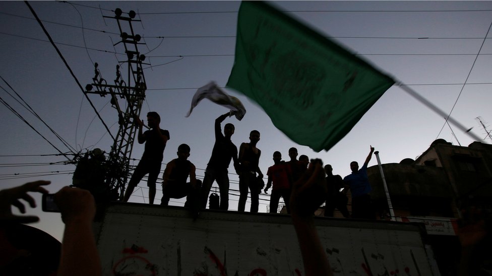مجموعة من الشباب يلوحون براية حماس في غزة