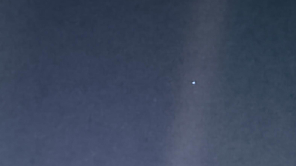 O que é um pontinho azul no céu com dois pontos brilhantes