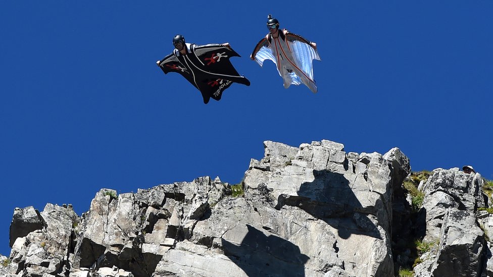 Two wingsuit flyers jumping off mountain