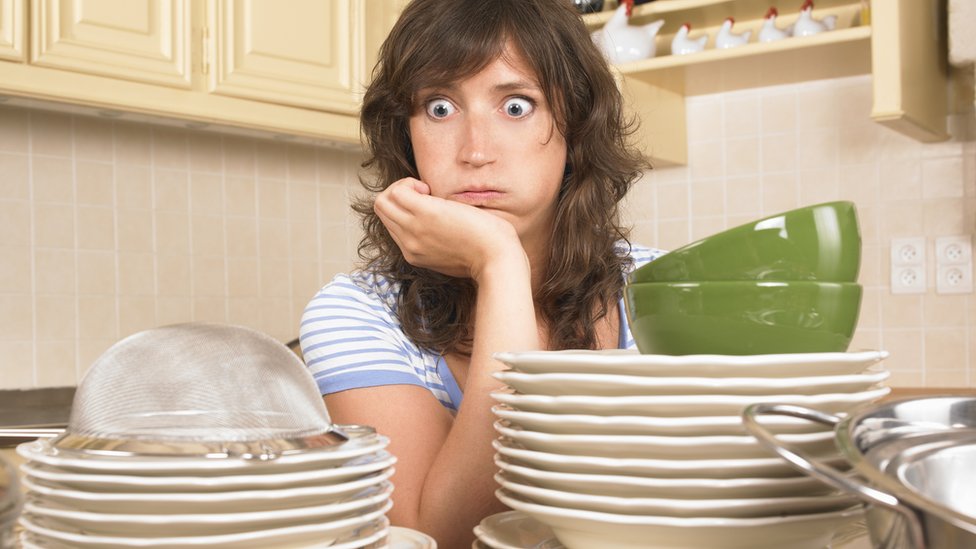 Mujer ante pila de cacharros