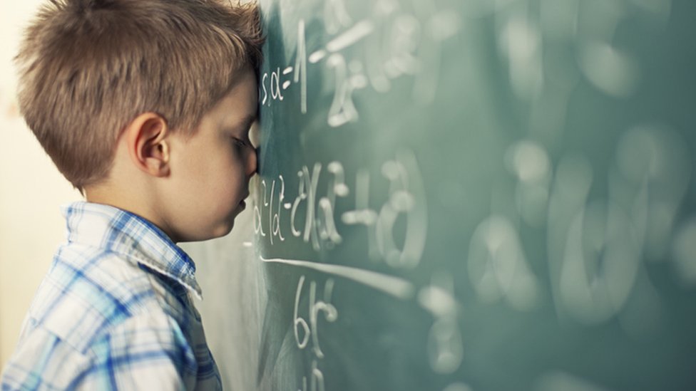 jovem professora ensinando aula de matemática para alunos na sala