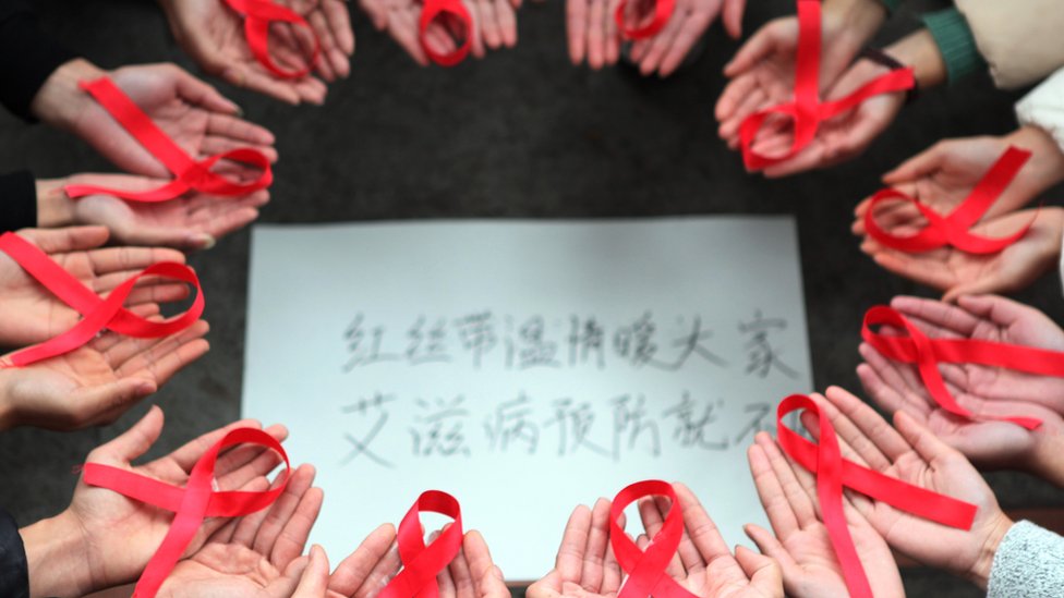 Voluntarios en china con cintas rojas