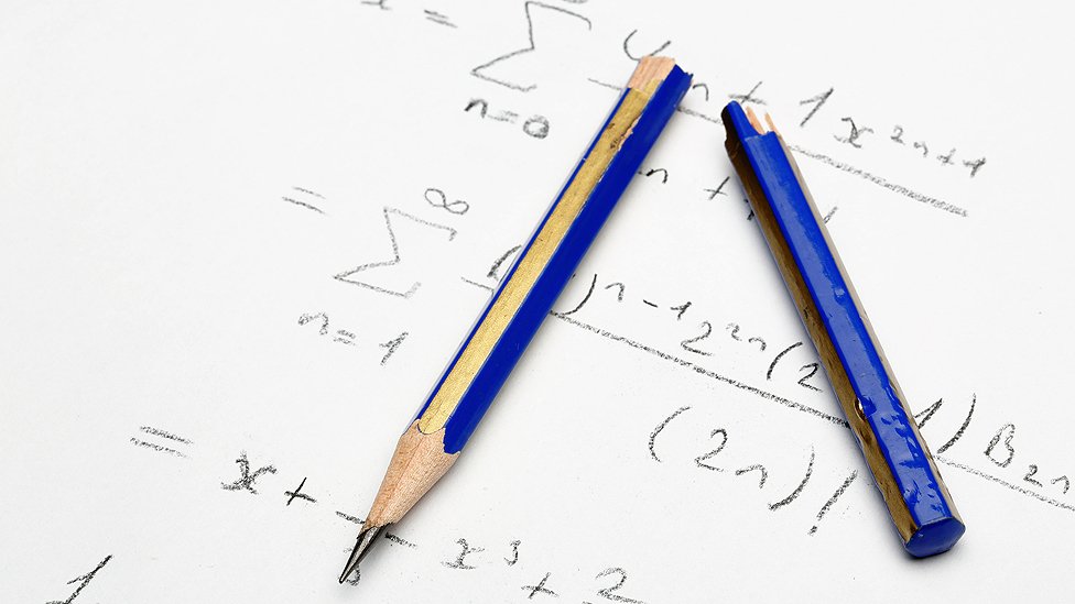 lápiz roto sobre hoja con álgebra