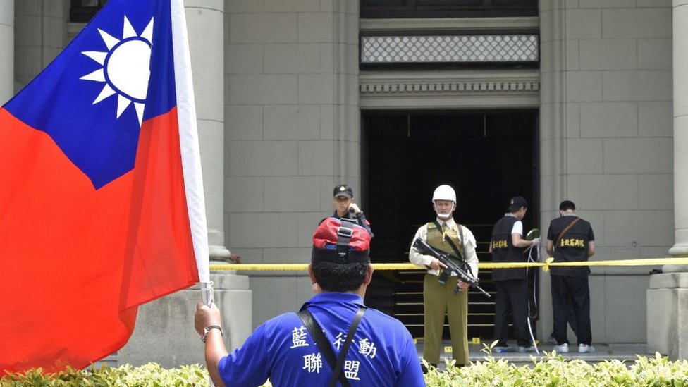 Un manifestante con una bandera de Taiwán frente a un edificio oficial en Taipei.