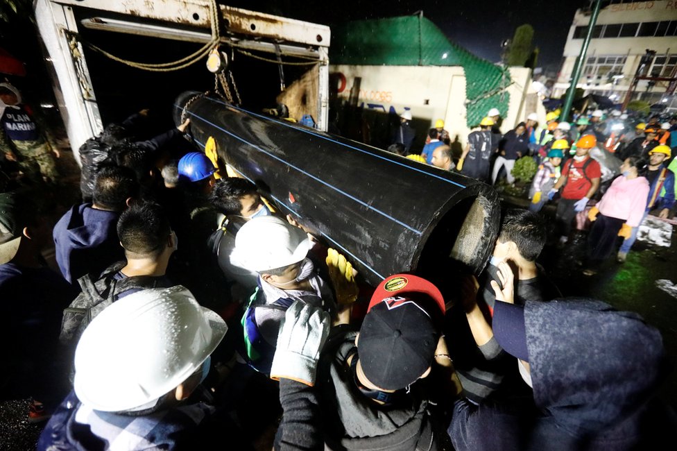 Rescatistas y voluntarios transportan un tubo en las inmediaciones del Colegio Enrique Rébsamen, del barrio Coapa, en el sureste de la Ciudad de México, parcialmente derrumbado por el terremoto de magnitud 7,1 que sacudió el país el martes.