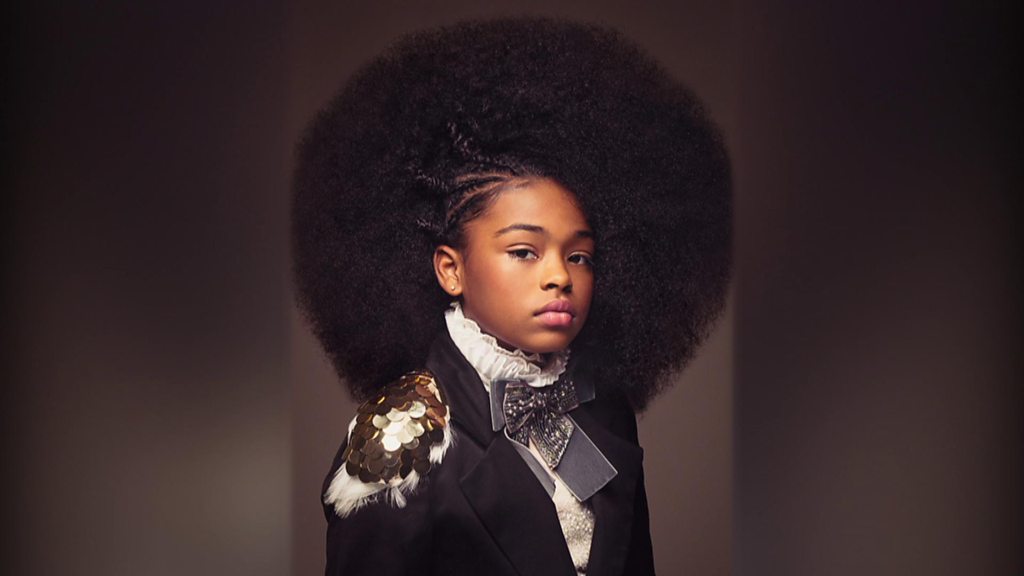 Une Femme Anxieuse D'âge Moyen Aux Cheveux Chauves De L'origine Ethnique  Africaine, Vêtue D'une Tenue De Data Scientist, Pose Dans Une Coiffure  Brossée à La Main Sur Un Fond Jaune Pastel.