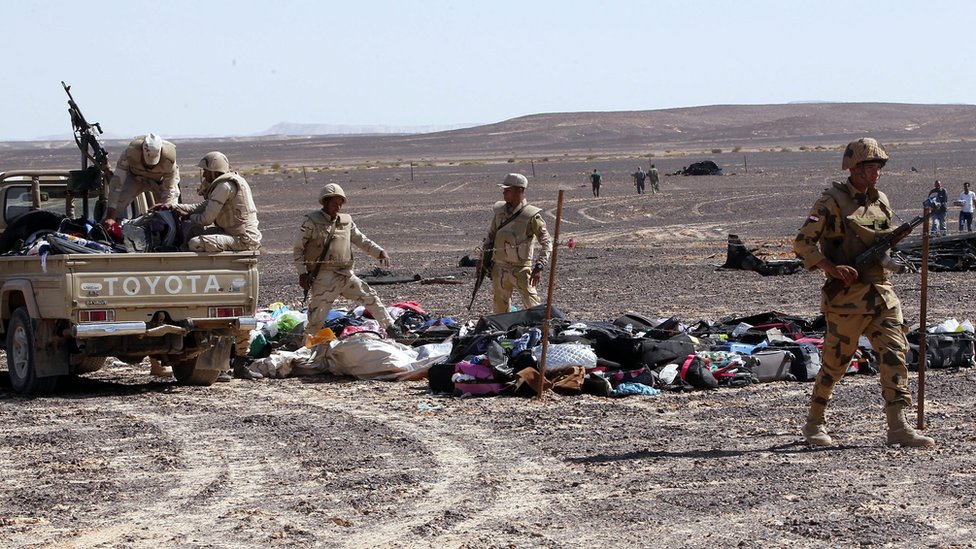 Soldados egipcios recogen las pertenencias de los pasajeros de un avión ruso que se estrelló en Sinaí en noviembre de 2015.