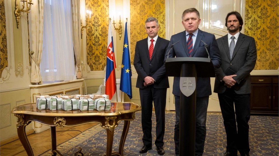 El primer ministro de Eslovaquia, Robert Fico (centro), el director de la Policía, Tibor Gaspar (izquierda) y el ministro del Interior, Robert Kalinak (derecha), al lado de varios fajos de euros.