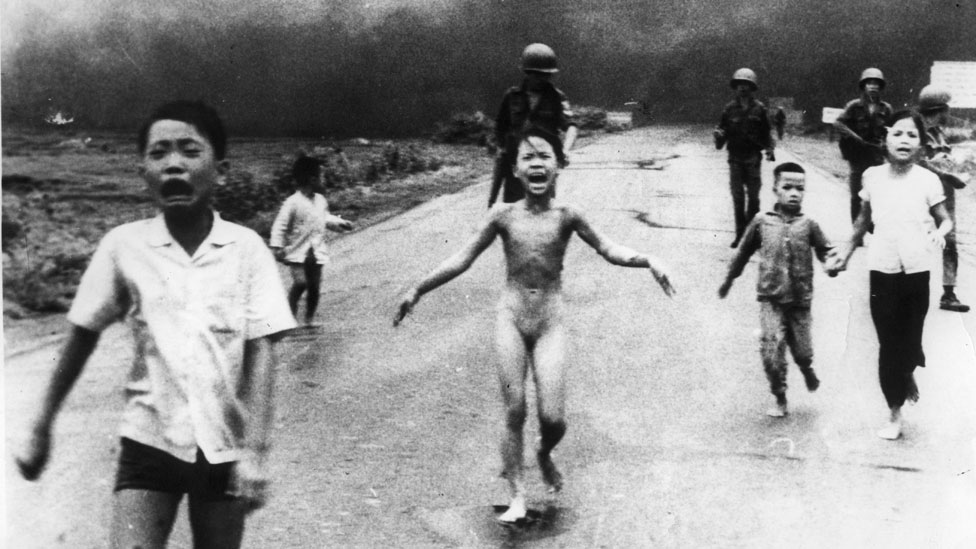 Foto icónica tomada por Nick Ut que muestra a Kim Phuc corriendo desnuda tras arrancarse la ropa de su cuerpo ardiente. La niña corre con otros niños que hyen horrorizados.