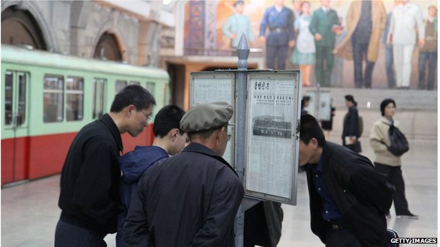 People reading newspaper in North Korea