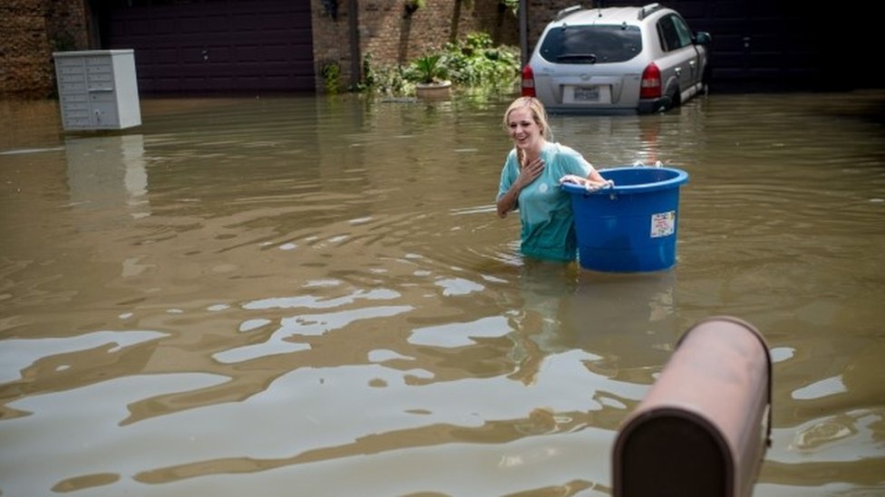 Jenna Fountain membawa ember di Regency Drive Port Arthur, Texas, yang kebanjiran, 1 September 2017