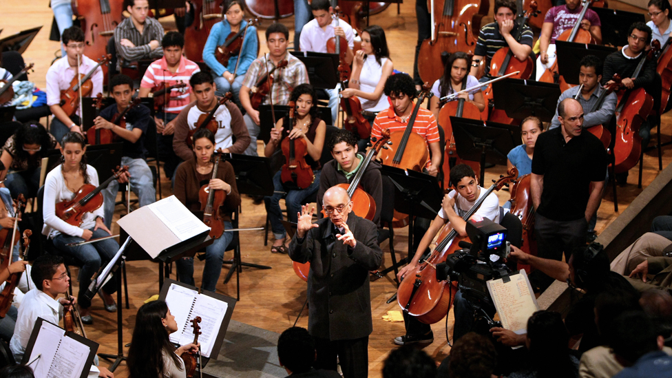 Abreu rodeado de un orquesta de jóvenes.