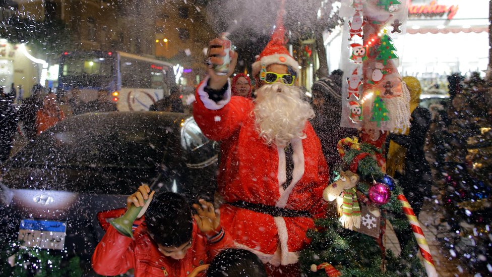 A man wearing a Santa Claus costume selling Santa Claus dolls as part of New Year"s Eve celebrations at a market in Cairo, Egypt, 31 December 2017