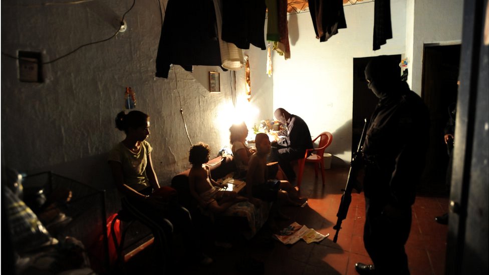 Policías revisan la casa de un sospechoso de pertenecer a las maras.