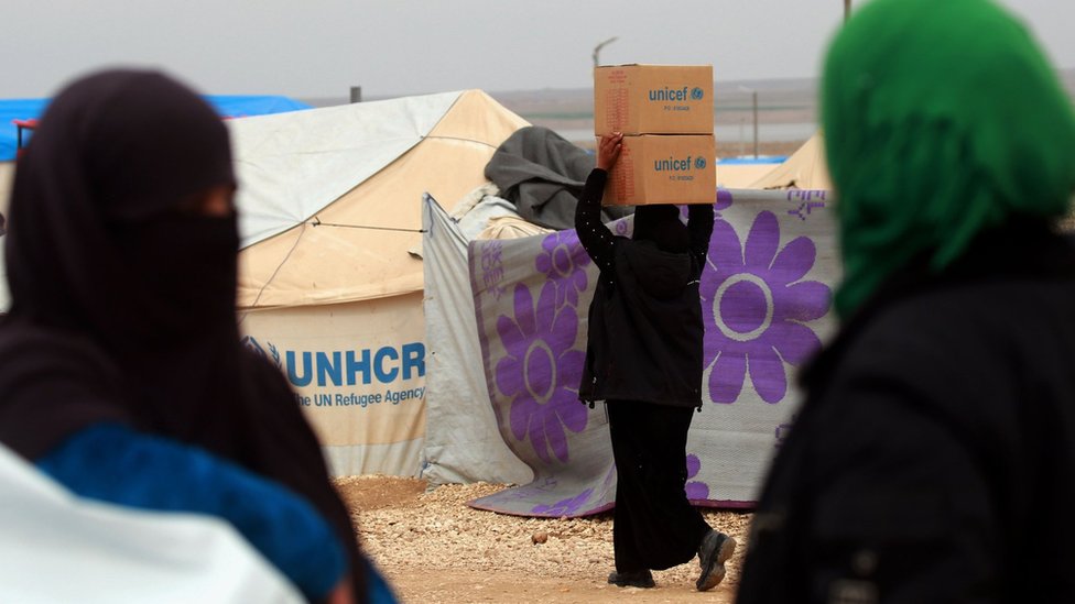 Una mujer carga cajas de asistencia humanitaria entregada por UNICEF, en un campo de refugiados en las zona de Hassakeh, en Siria, febrero 26 de 2018.
