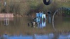 A children's playground is seen partially submerged in floodwaters