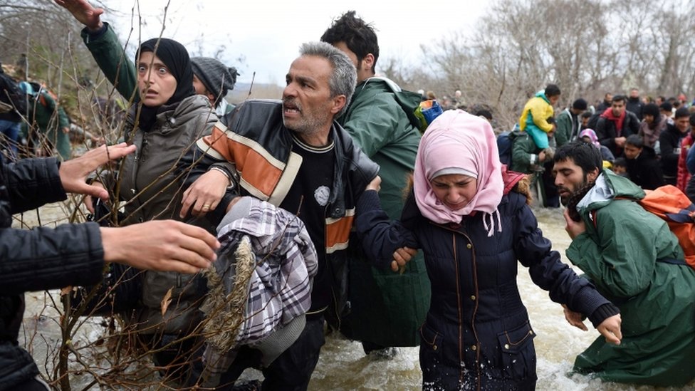 لاجئون يعبرون نهرا في الطريف لمقدونيا