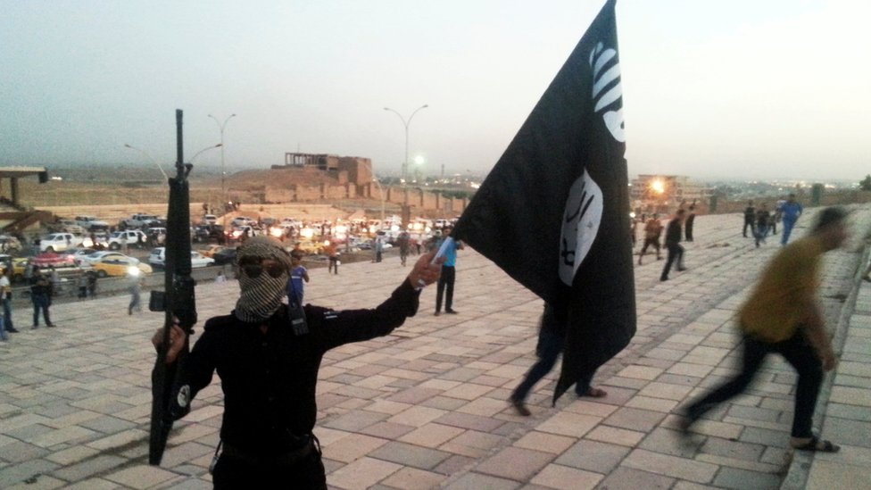 صورة أرشيفية لأحد مقاتلي التنظيم يرفع علمه فور استيلاء التنظيم على الموصل