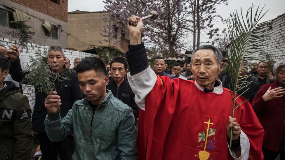 Chinese Catholic deacon sprays holy water on worshippers at the Palm Sunday Mass during the Easter Holy Week at an 'underground' or 'unofficial' church on April 9, 2017 near Shijiazhuang, Hebei Province, China.