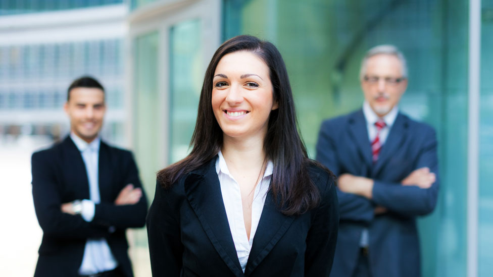 Mujer en el frente y dos colegas hombres al fondo