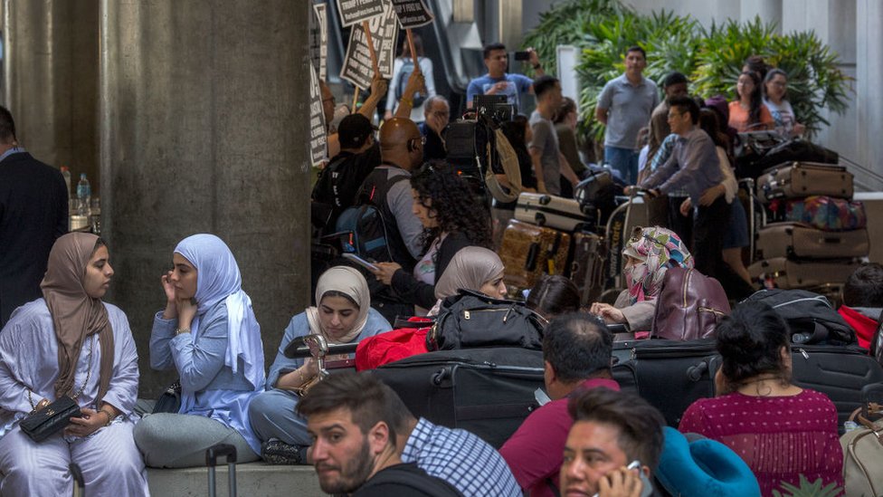 Para pegiat berunjuk rasa di Bandara Internasional Los Angeles (LAX), AS pada hari pertama penerapan kembali sebagian larangan perjalanan Trump, yang sementara melarang pendatang dari enam negara mayoritas Muslim.