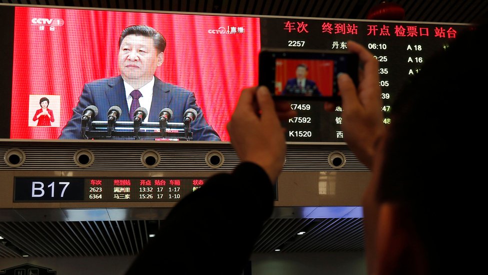 A passenger takes pictures of Chinese President Xi Jinping at Shenyang railway station in China