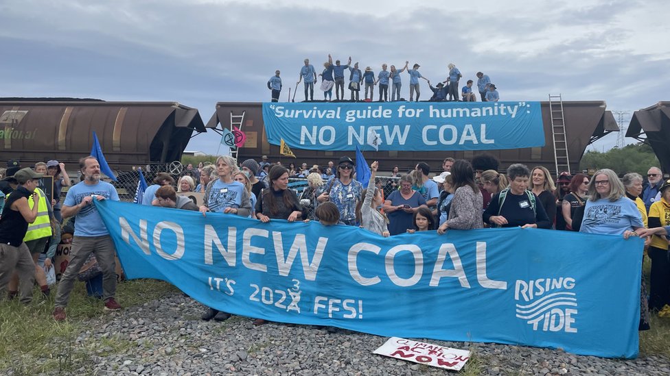 Australia climate activists shovel coal off train