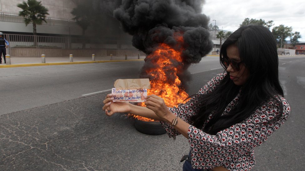 Una mujer protesta en tegucigalpa contra el gobierno de Hernández.