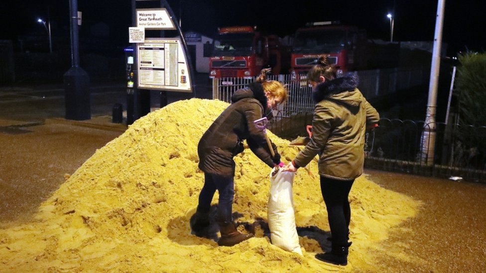 اشخاص يملؤون اكياس الرمل في غريت يارماوث