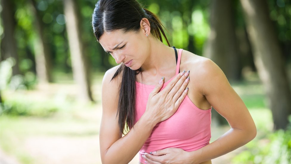 Mujer joven con dolor en el pecho