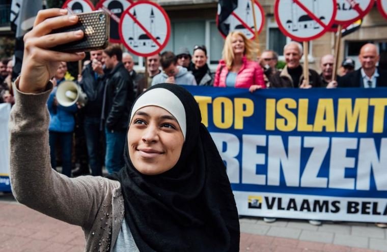 Photo of Zakia Belkhiri standing with protesters from Vlaams Belang