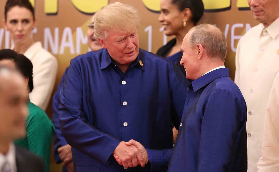 US President Donald Trump (L) shakes hands with Russia