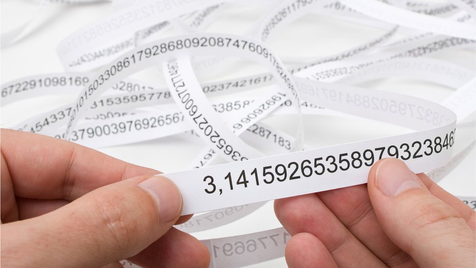 Manos sosteniendo papel con dígitos interminables de Pi.