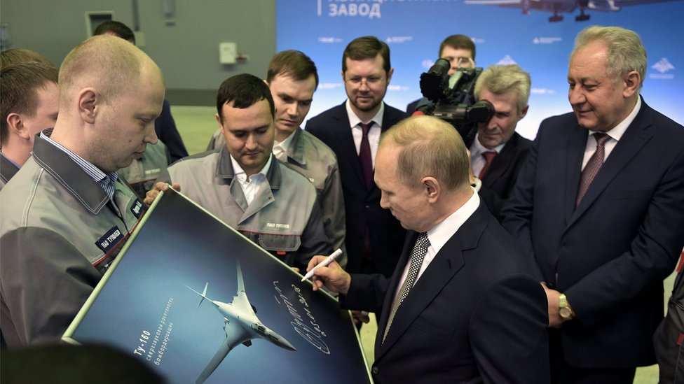El presidente ruso, Vladimir Putin, firma una fotografía del bombardero nuclear TU-160M.