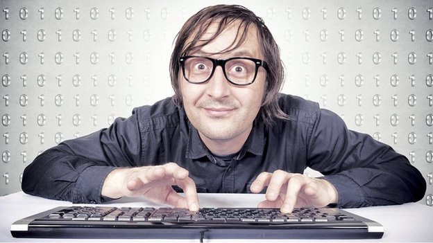 man with glasses typing on computer keyboard