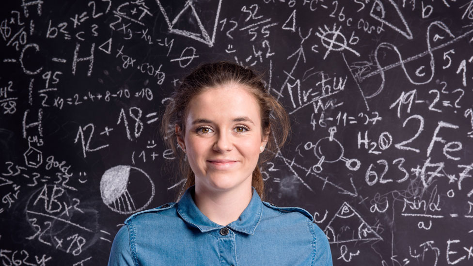 Una chica adolescente frente a una pizarra