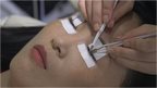 A woman getting eyelash extensions