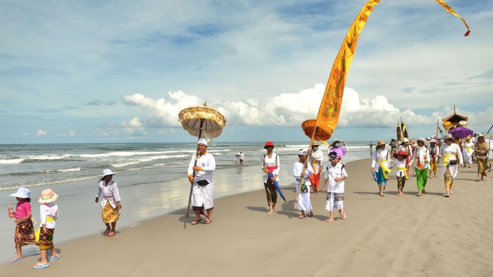 Hinduistas de Bali en la playa para la ceremonia de purificación conocida como 