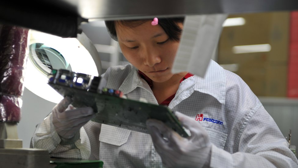 在中國深圳工廠組裝蘋果零件的富士康員工。