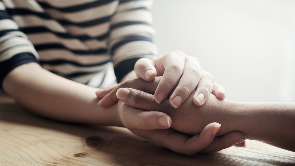 Dos personas agarradas de la mano.