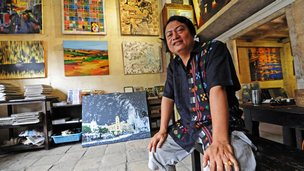 Gallery owner Aung Soe Min sitting in his gallery