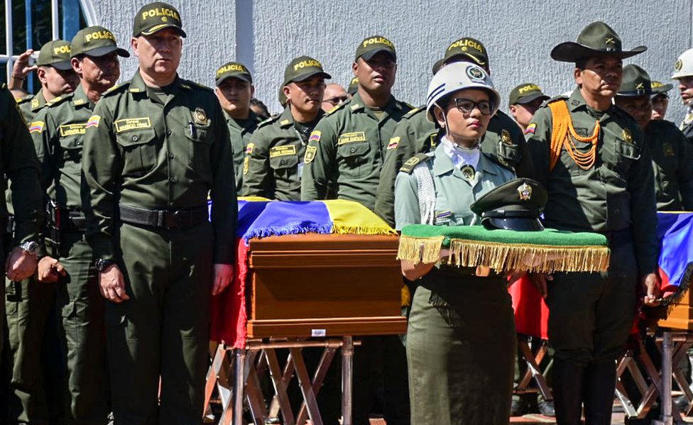 Policías llevan ataúdes de víctimas