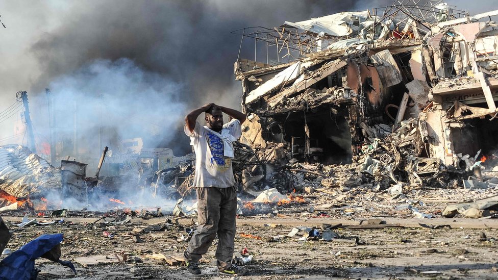 Un hombre reacciona al ver un cuerpo en medio de la explosión.