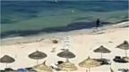 Still from footage showing Tunisia gunman running along beach