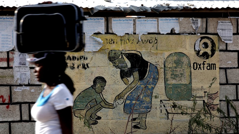 Una mujer pasa delante de un anuncio de Oxfam en Puerto Príncipe, Haití.