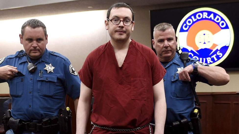 James Holmes esposado y custodiado.