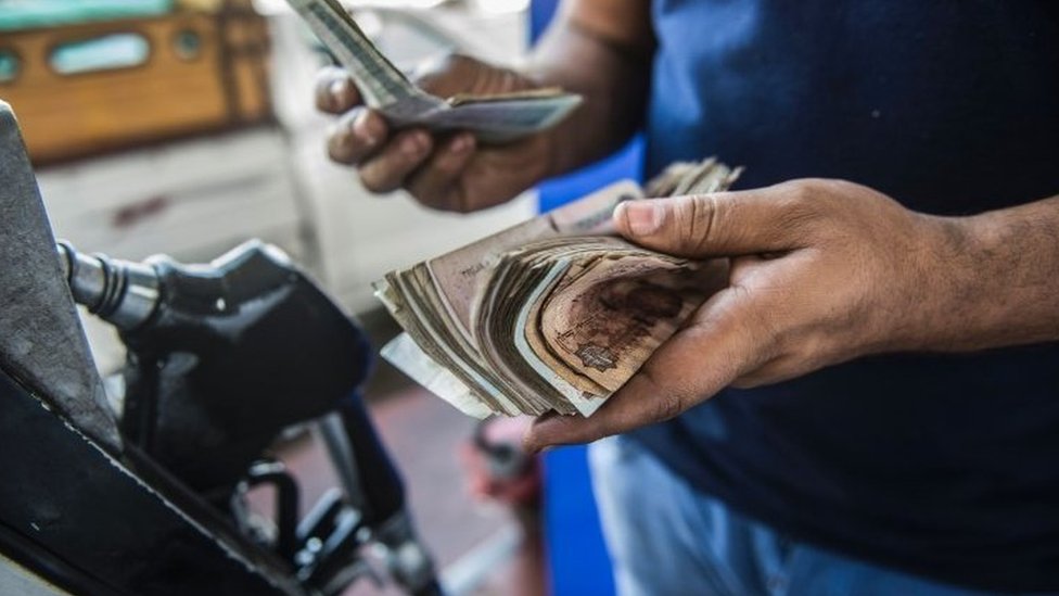 شخص يعد الأموال في محطة بنزين في مصر