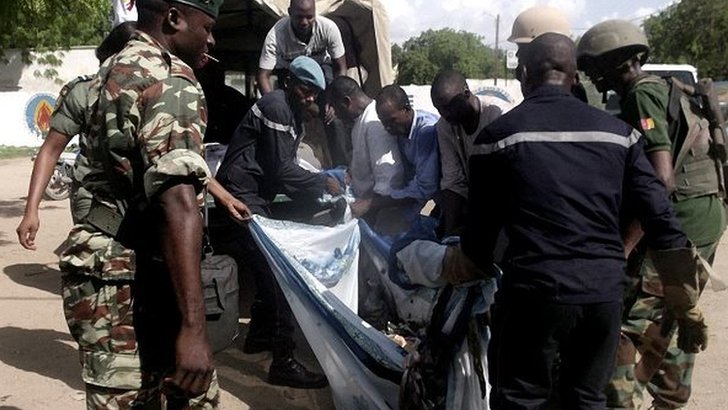 Security forces transport with a blanket the remains of some of the eleven victims of a double blast in the northern Cameroonian city of Maroua on July 22, 2015