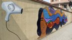 Street art of woman drying her colourful hair